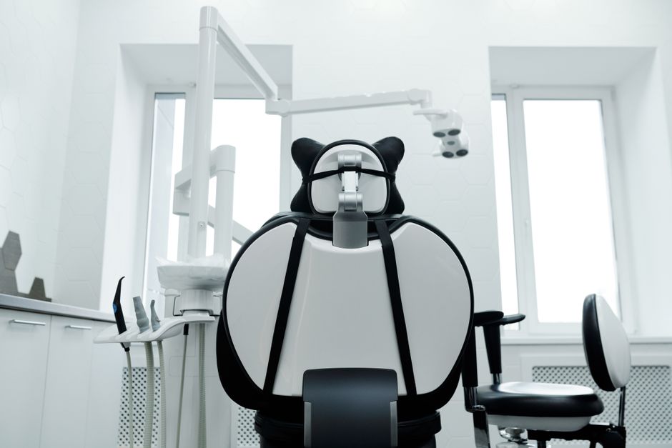 Modern dental treatment room with a chair and overhead equipment